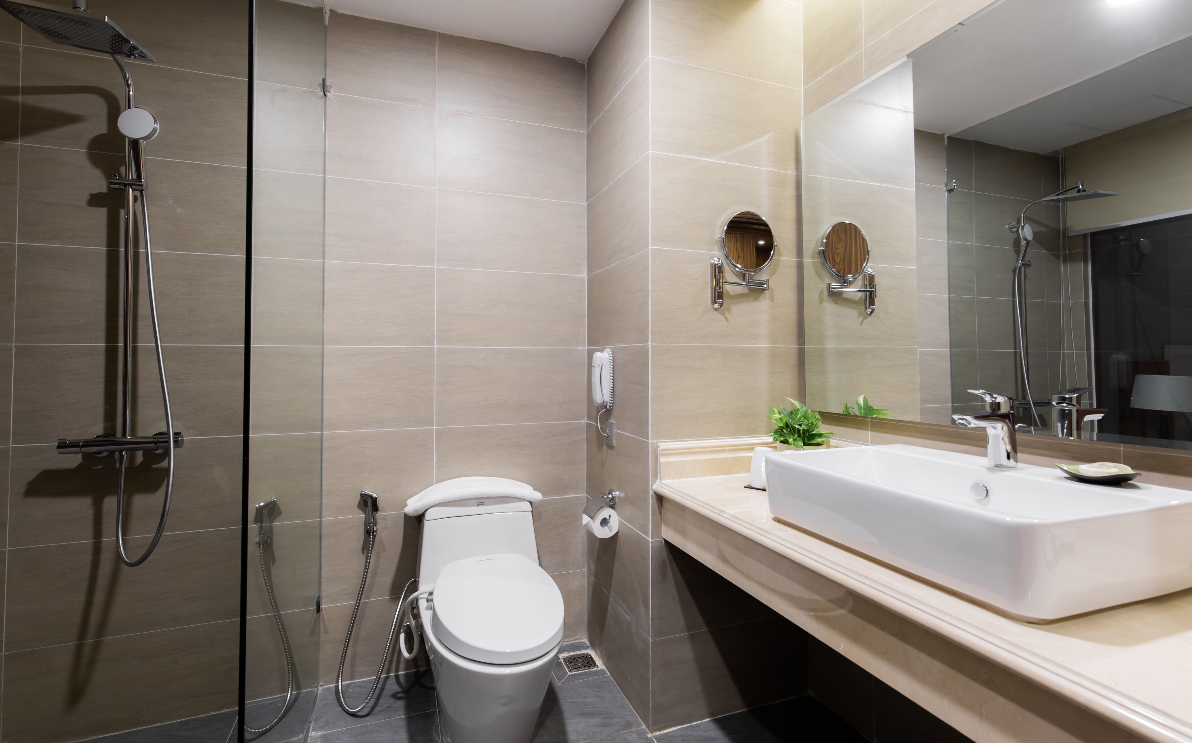 A modern bathroom with a toilet, bidet, and shower.