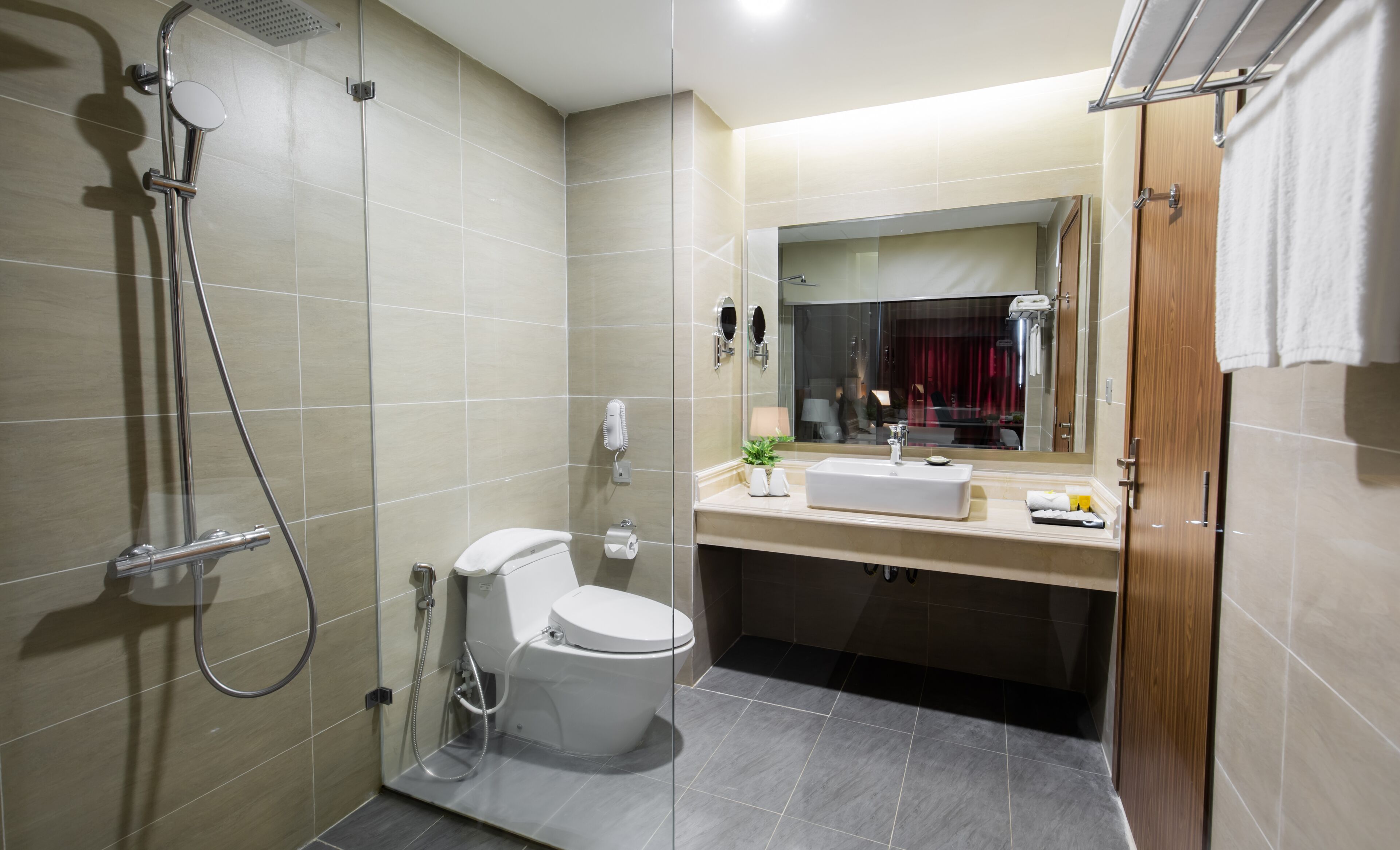 Een moderne badkamer met douche, toilet en wastafel.