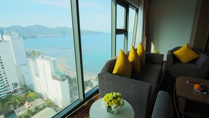 A modern hotel room with a large window offering a view of the sea and cityscape. - Muong Thanh Luxury Vien Trieu Hotel (Bac Nha Trang)