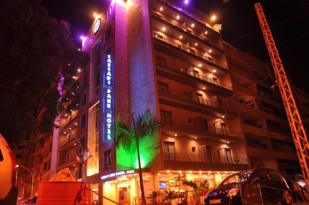 A multi-story hotel with balconies and a prominent sign reading "Café Park Hotel".