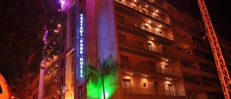 A multi-story hotel with balconies and a prominent sign reading "Café Park Hotel".