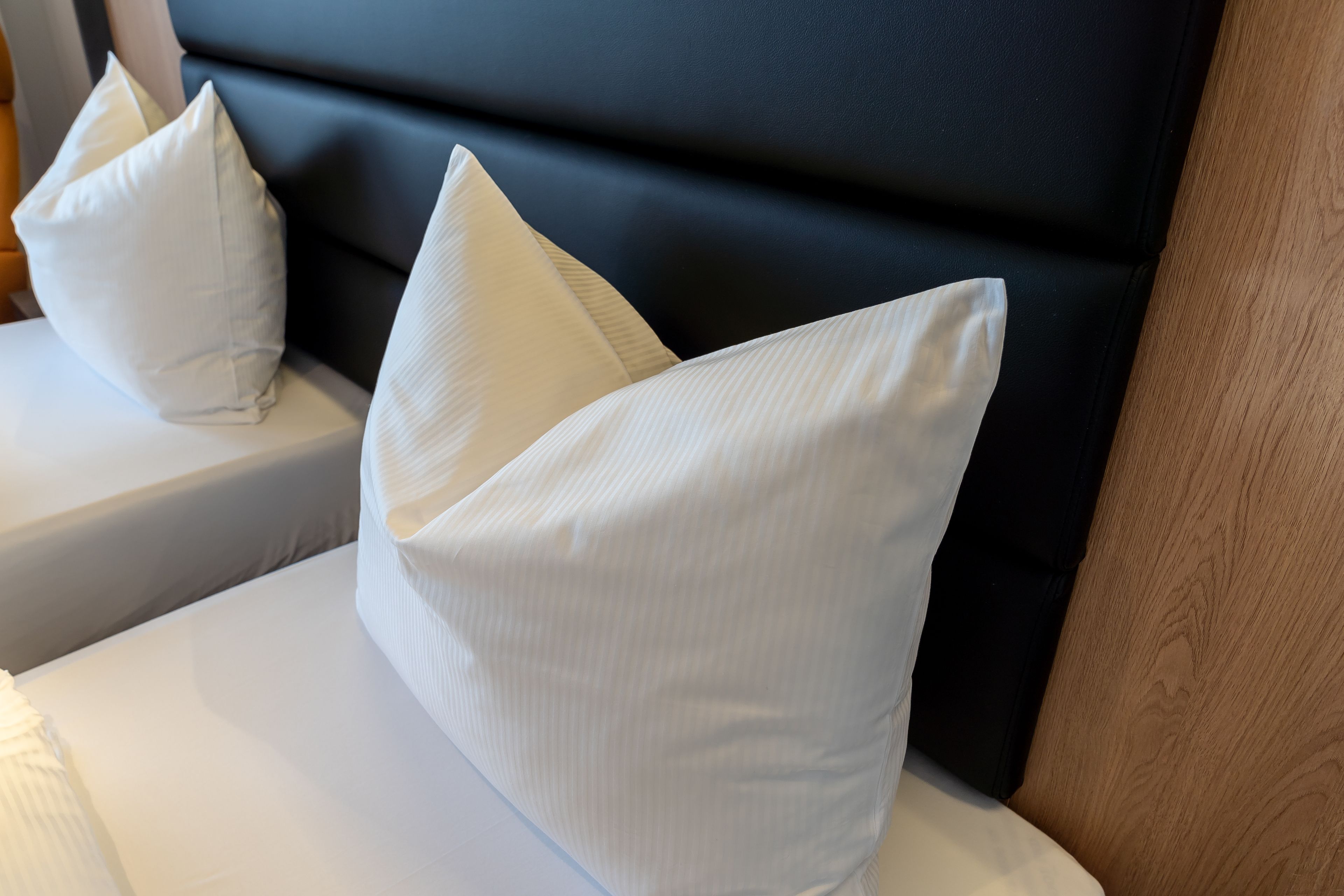 A bed with white pillows and a black headboard.