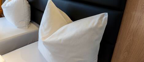 A bed with white pillows and a black headboard.