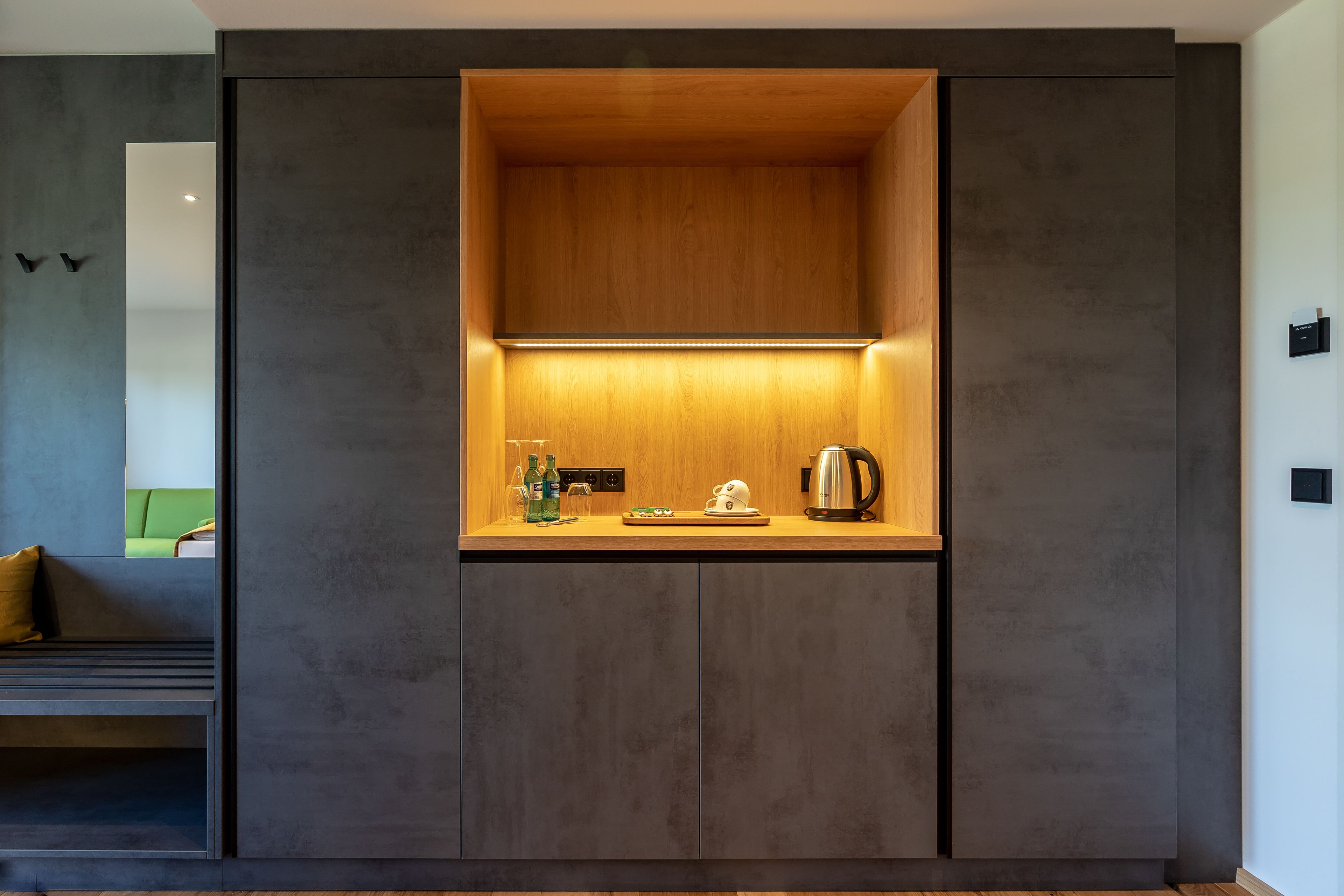 Una cocina moderna con encimera de madera, un hervidor y una botella de agua.
