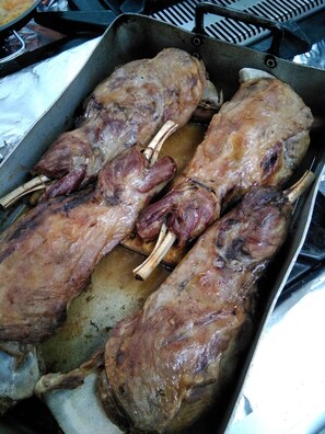 A tray with roasted lamb shanks. - Pensión O Noso (Porto do Son)