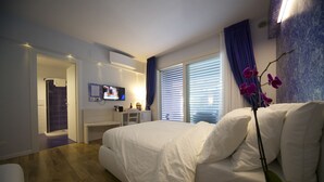 Een moderne slaapkamer met een groot bed, een bureau en een televisie.