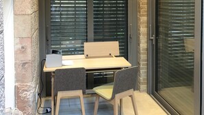 Een hoekkamer met een bureau, twee stoelen, een projector en een plafondventilator.