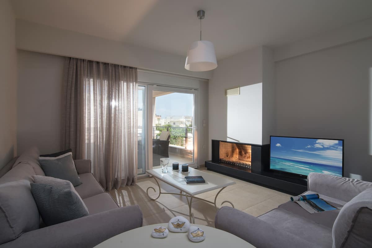 Ein modernes Wohnzimmer mit einer Couch, einem Couchtisch und einem Fernseher.