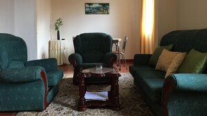 A living room with two green armchairs, a wooden coffee table, and a painting on the wall. - HOUSE CARVOEIRO, SEA AND MOUNTAIN VIEW! (São Vicente, Madeira)