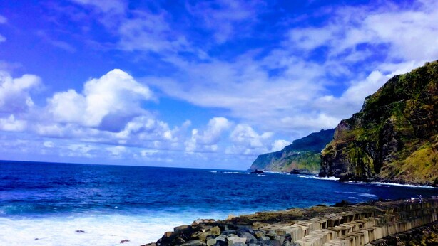 A coastal scene with a clear sky, ocean waves, and a rocky cliff. - HOUSE CARVOEIRO, SEA AND MOUNTAIN VIEW! (São Vicente, Madeira)