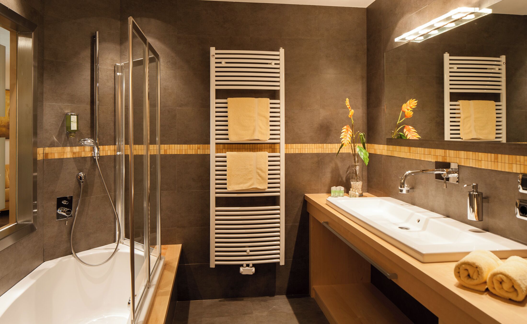 A modern bathroom with a glass-enclosed shower, a white sink, and a mirror above the vanity.