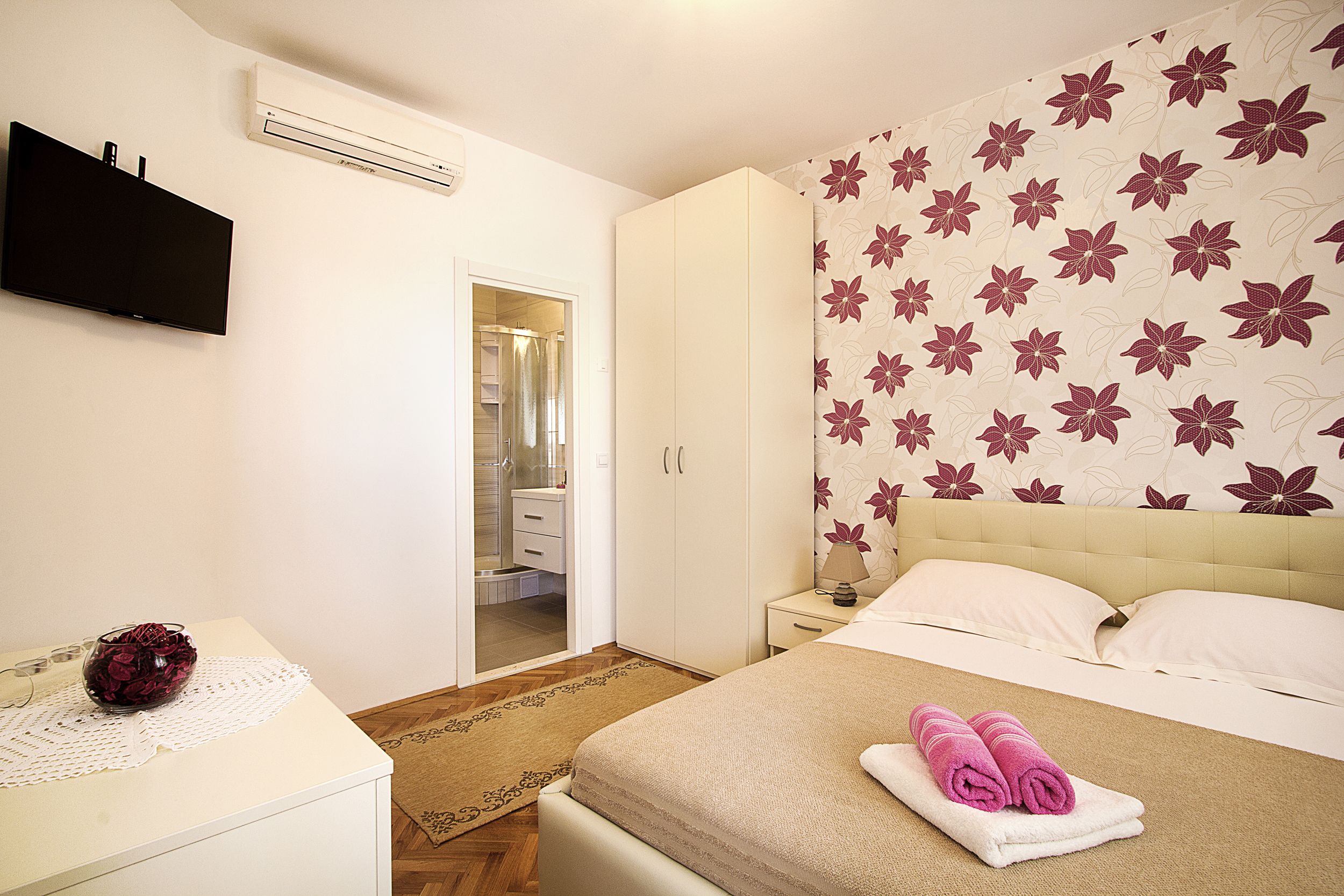 A bedroom with a bed, bedside table, and a wardrobe.