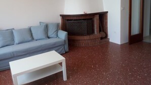 A living room with a sofa, a white coffee table, and a fireplace. - Casa del sole, breathtaking view of the Pontine islands and the Circeo (Sperlonga)