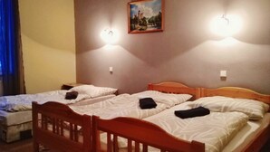 Quarto de hotel com duas camas de solteiro, cabeceiras de madeira e um quadro na parede.