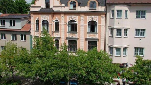 Um edifício de vários andares com arquitetura clássica, com janelas em arco e detalhes decorativos.