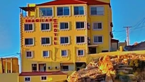 A yellow building with multiple windows and a red roof, labeled "SHAQILAN HOTEL." - Shaqilath Hotel (Wadi Musa)