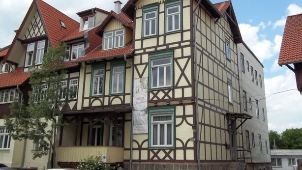 A traditional half-timbered building with multiple windows and a sign indicating it is a hotel. - *Watch now! In the beautiful Wernigerode 250 m to the center - half-timbered house (Wernigerode)
