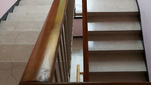 A staircase with a wooden handrail leading up to a window with frosted glass. - STAY VENICE GUESTHOUSE (Mestre)