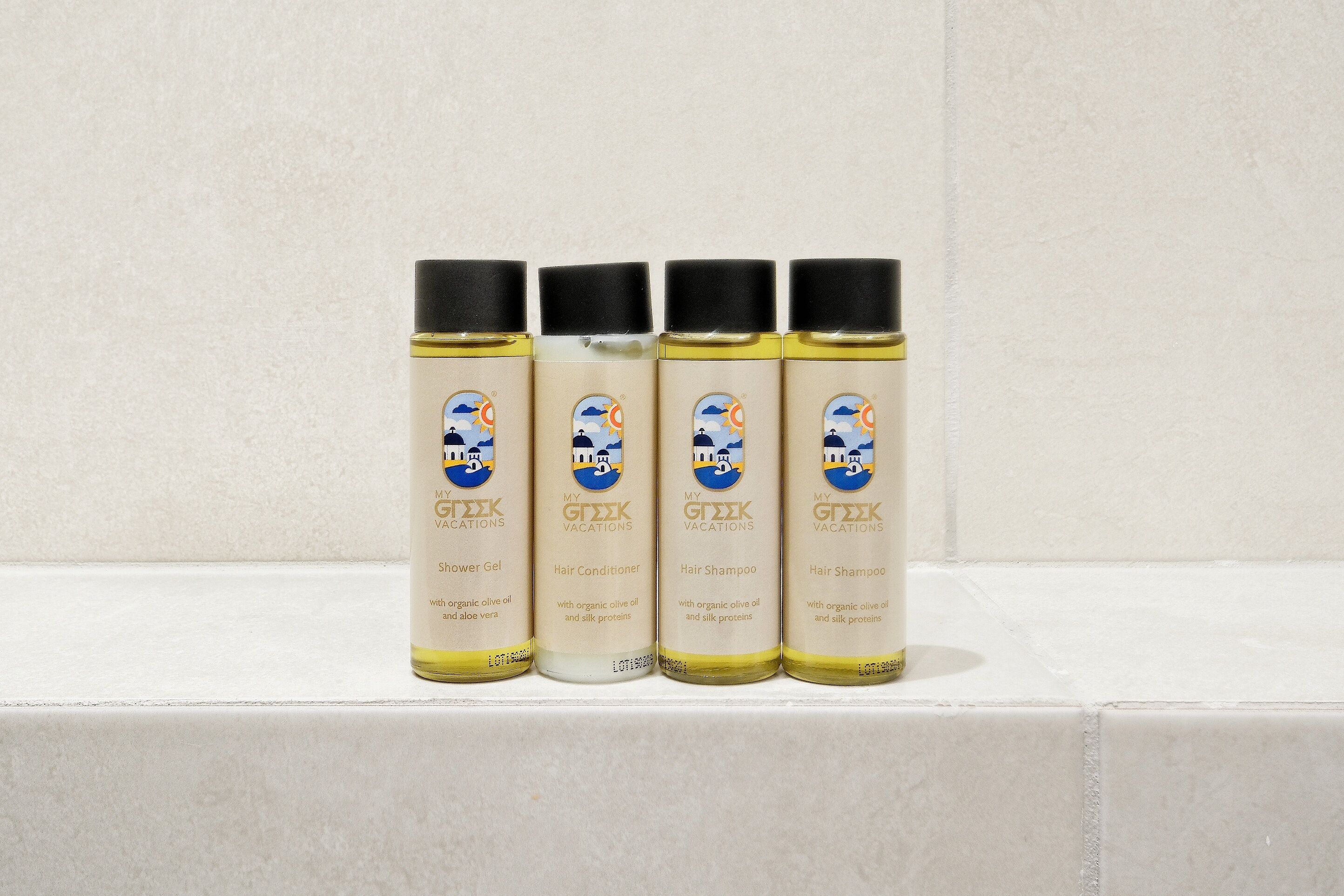 Four bottles of My GEEK Vacations products on a tiled surface.