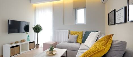 Una sala de estar moderna con un sofá, una mesa de centro, un televisor y un radiador.