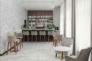 A bar area with a marble floor, wooden chairs, and a bar counter stocked with bottles. - Harvey Spa Hotel (Frantiskovy Lazne)