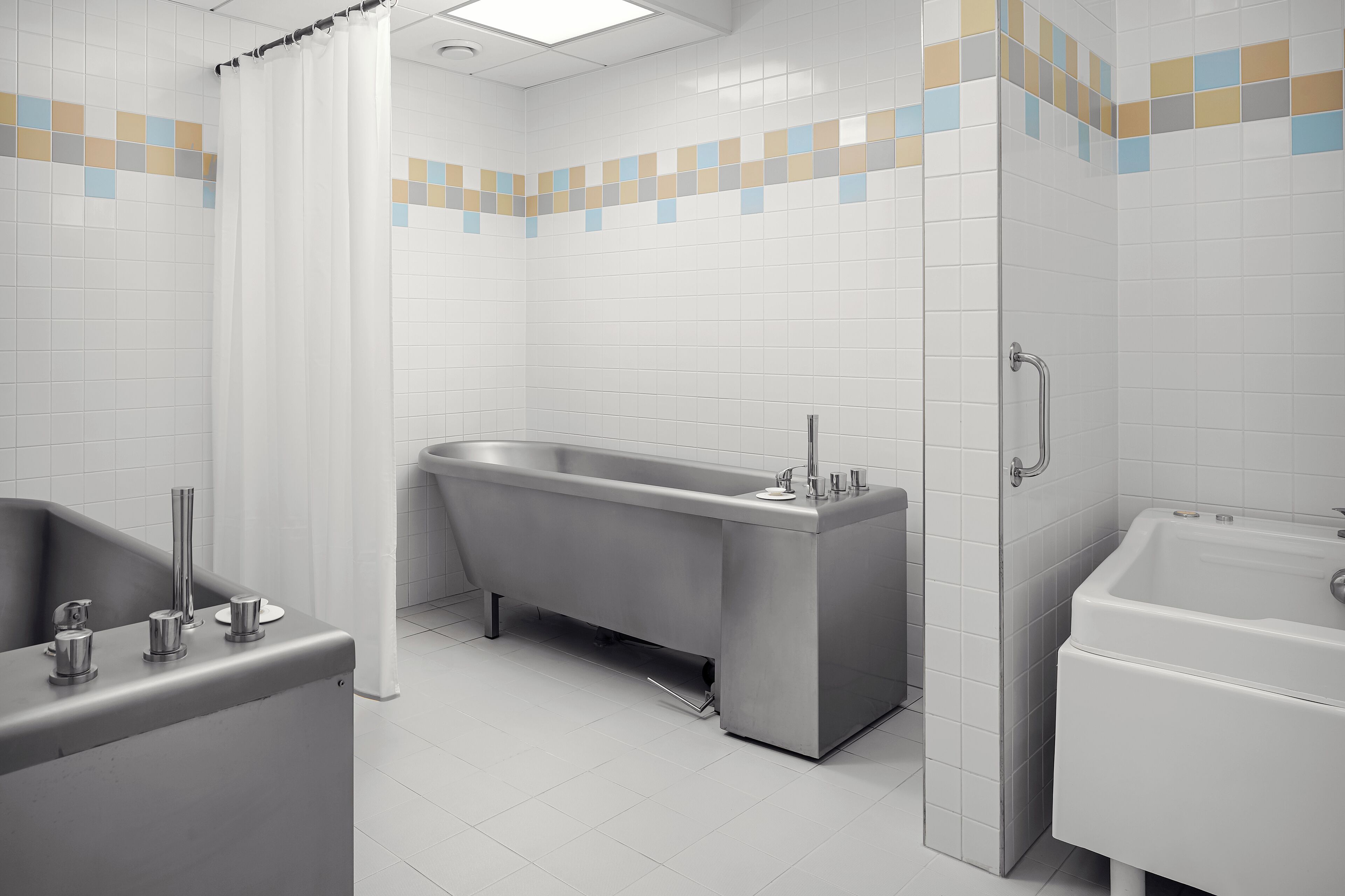Un baño moderno con una bañera independiente, un lavamanos separado y una zona de ducha.