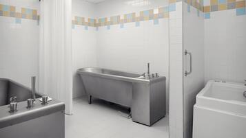 Un baño moderno con una bañera independiente, un lavamanos separado y una zona de ducha.