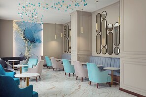 A modern lounge area with seating arrangements, a marble floor, and decorative wall art. - Harvey Spa Hotel (Frantiskovy Lazne)