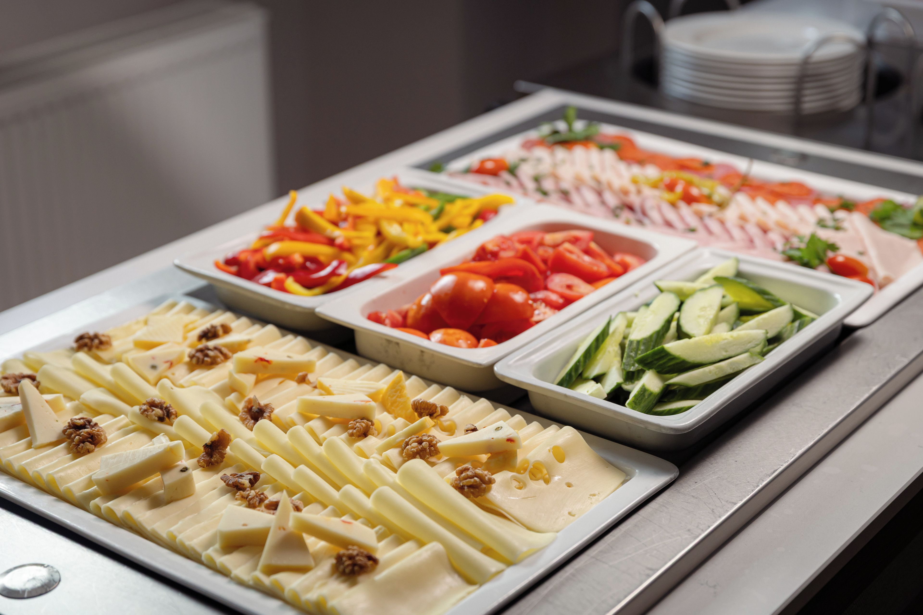 A buffet with various food options including fruits, vegetables, and cheese.