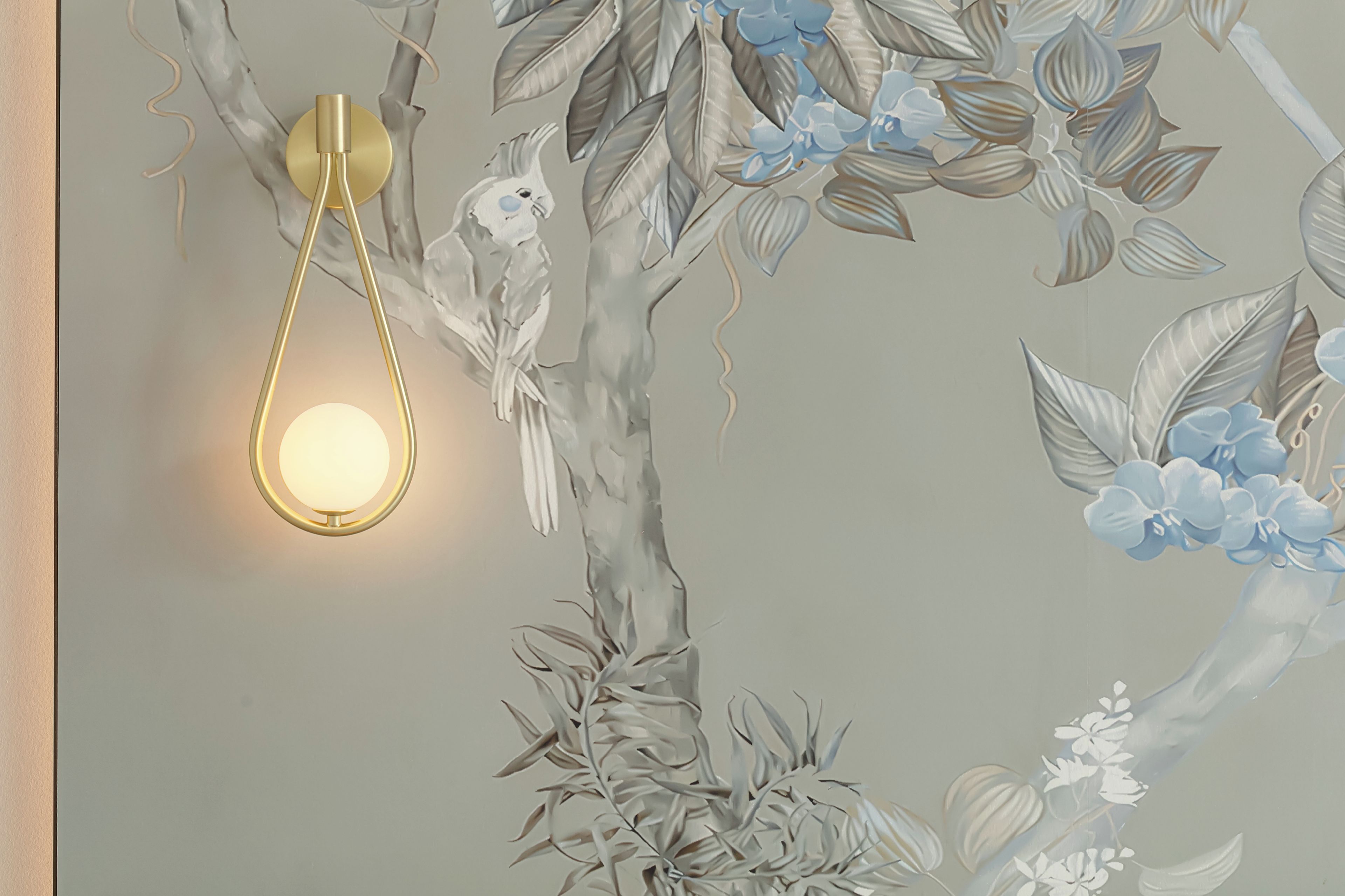 A wall with a textured floral design and a modern light fixture.