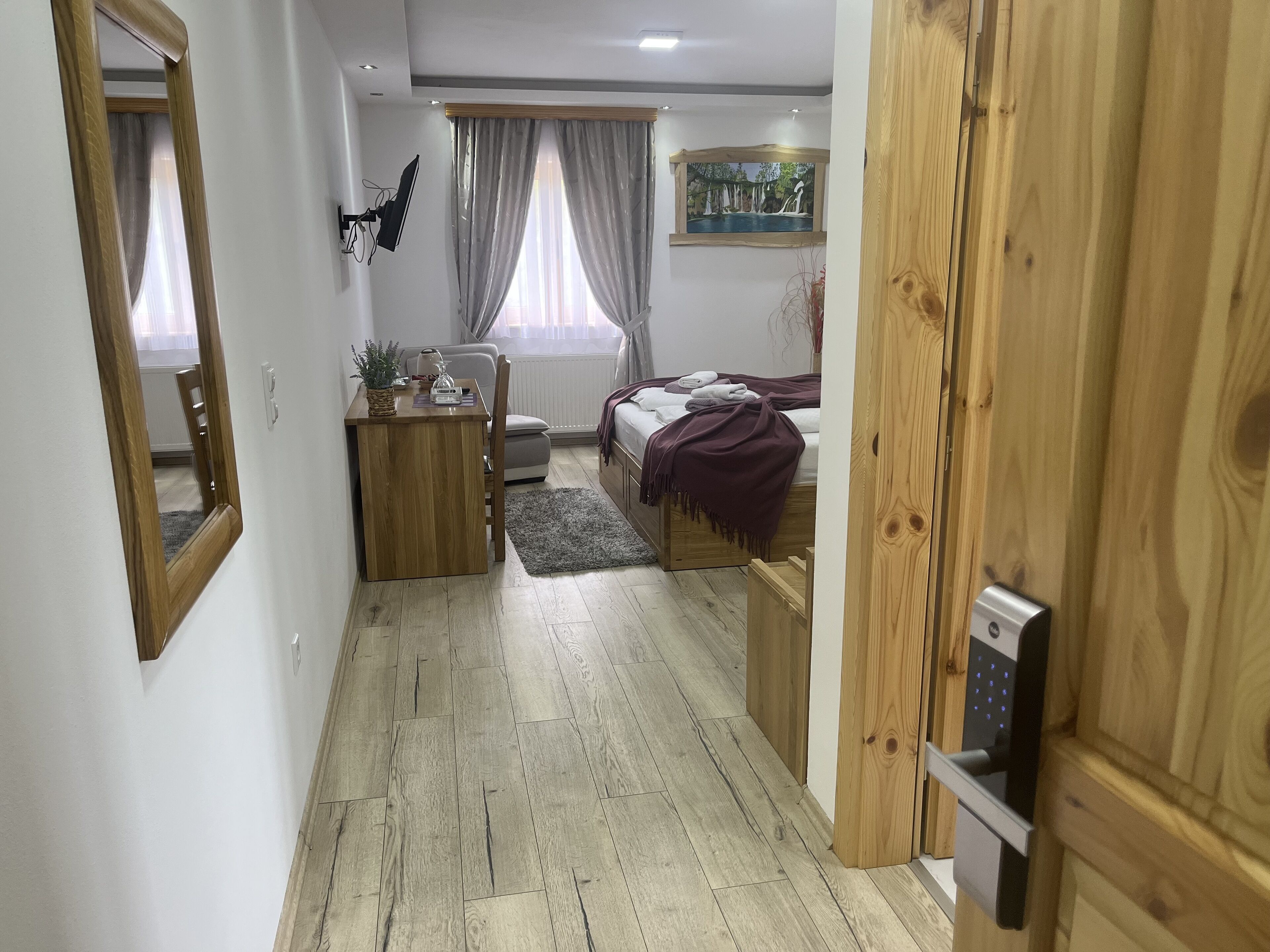 Un dormitorio con cama, mesita de noche, lámpara y un cuadro en la pared.