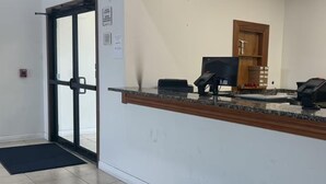 A reception area with a glass door, a reception desk, a telephone, and a small storage cabinet. - Surestay Best Western Obetz Rickenbacker Airport (Columbus)