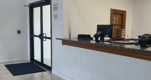 A reception area with a glass door, a reception desk, a telephone, and a small storage cabinet. - Surestay Best Western Obetz Rickenbacker Airport (Columbus)