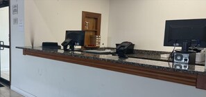 A reception desk with a computer, telephone, and a small cabinet. - Surestay Best Western Obetz Rickenbacker Airport (Columbus)