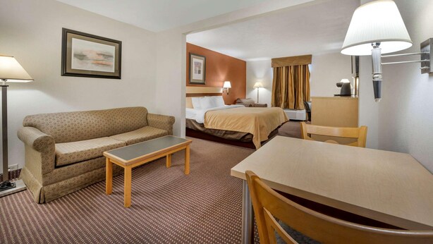 A hotel room with a sofa, a small table, a bed with a headboard, a desk with a chair, and two lamps. - Surestay Best Western Obetz Rickenbacker Airport (Columbus)