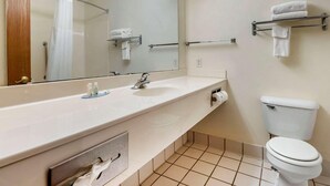 Een badkamer met een wastafel, spiegel, handdoekhouder en toilet.