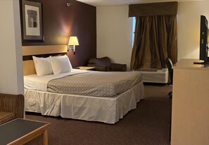 A hotel room with a large bed, a desk, a chair, a lamp, a television, and a window with curtains. - Surestay Best Western Obetz Rickenbacker Airport (Columbus)