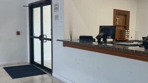 A reception area with a glass door, a reception desk, a telephone, and a small storage cabinet. - Surestay Best Western Obetz Rickenbacker Airport (Columbus)