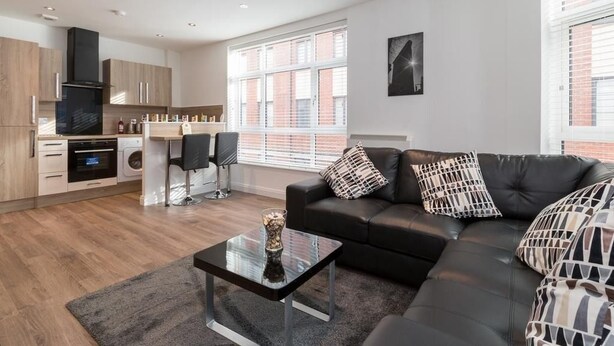 Een modern appartement met keuken, eethoek en woonkamer.