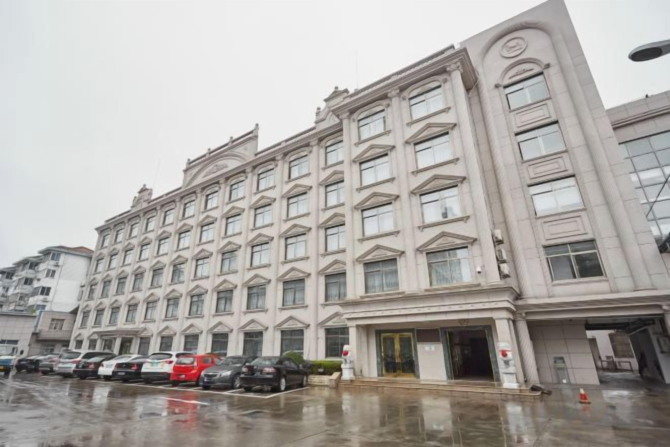 Hotel de vários andares com fachada simétrica, janelas amplas e entrada central.