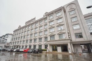A multi-story hotel with a symmetrical facade, large windows, and a central entrance. - Jinxiu Hotel (Shanghai)