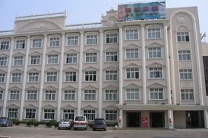 A multi-story building with a symmetrical facade, large windows, and a central entrance. - Jinxiu Hotel (Shanghai)