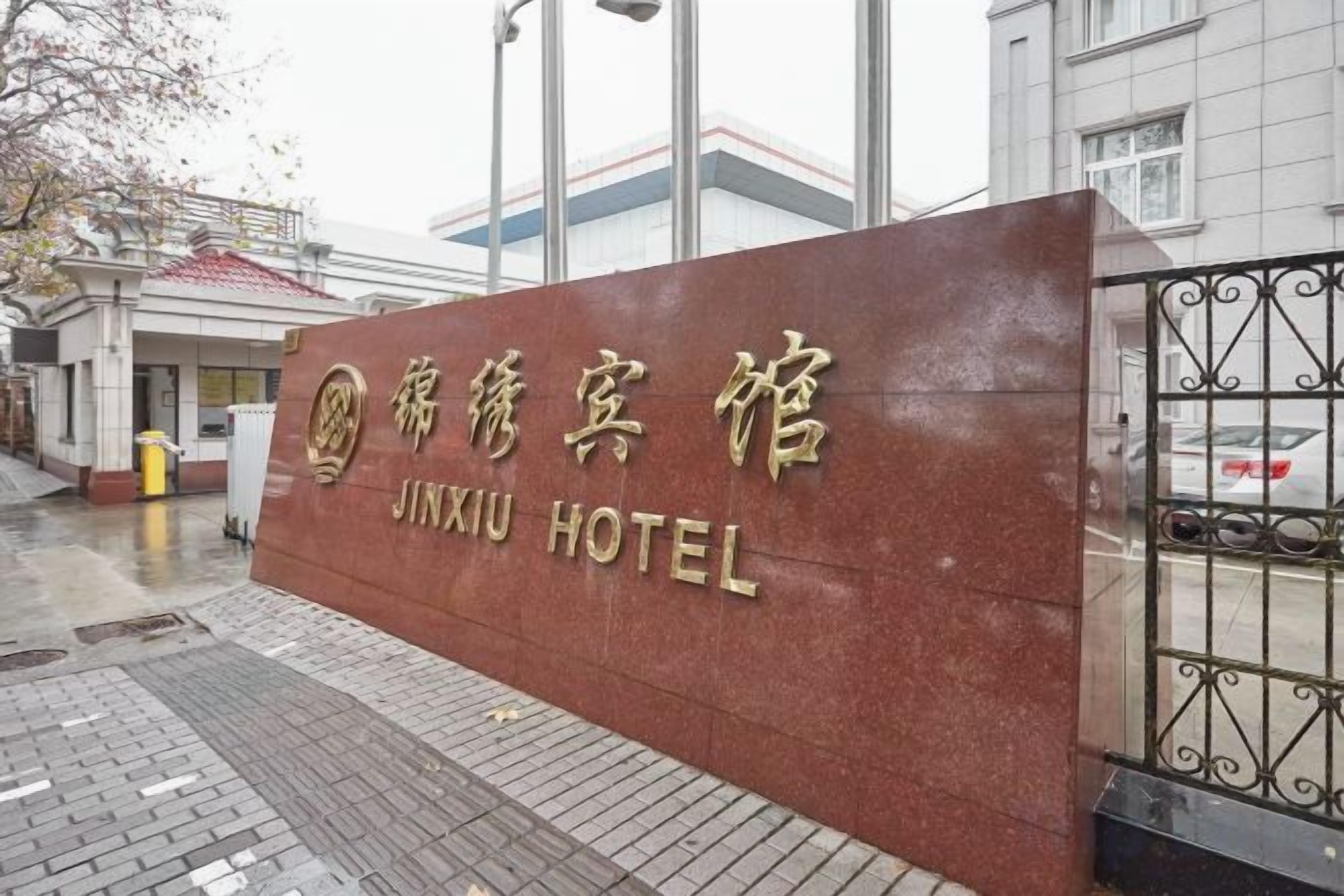 A hotel sign with the name 'JINXIU HOTEL' in both Chinese and English.