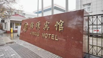 A hotel sign with the name 'JINXIU HOTEL' in both Chinese and English.