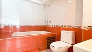Une salle de bain avec une baignoire, des toilettes et une douche.