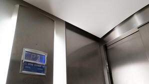 Un ascenseur doté d’un écran numérique indiquant la limite de poids et d’un panneau de commande.