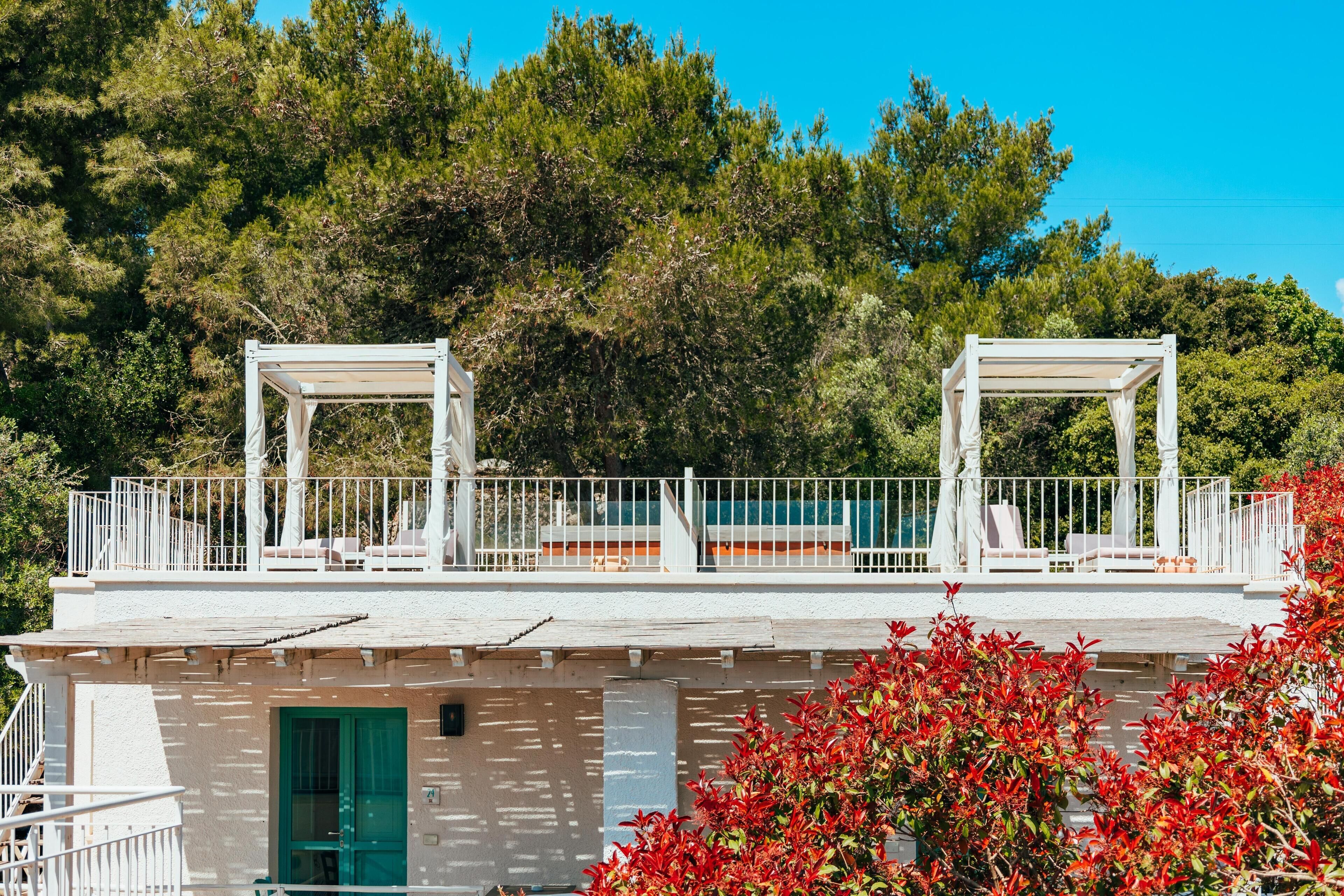 Un immeuble de deux étages doté d’un balcon, de balustrades blanches et d’une porte verte.
