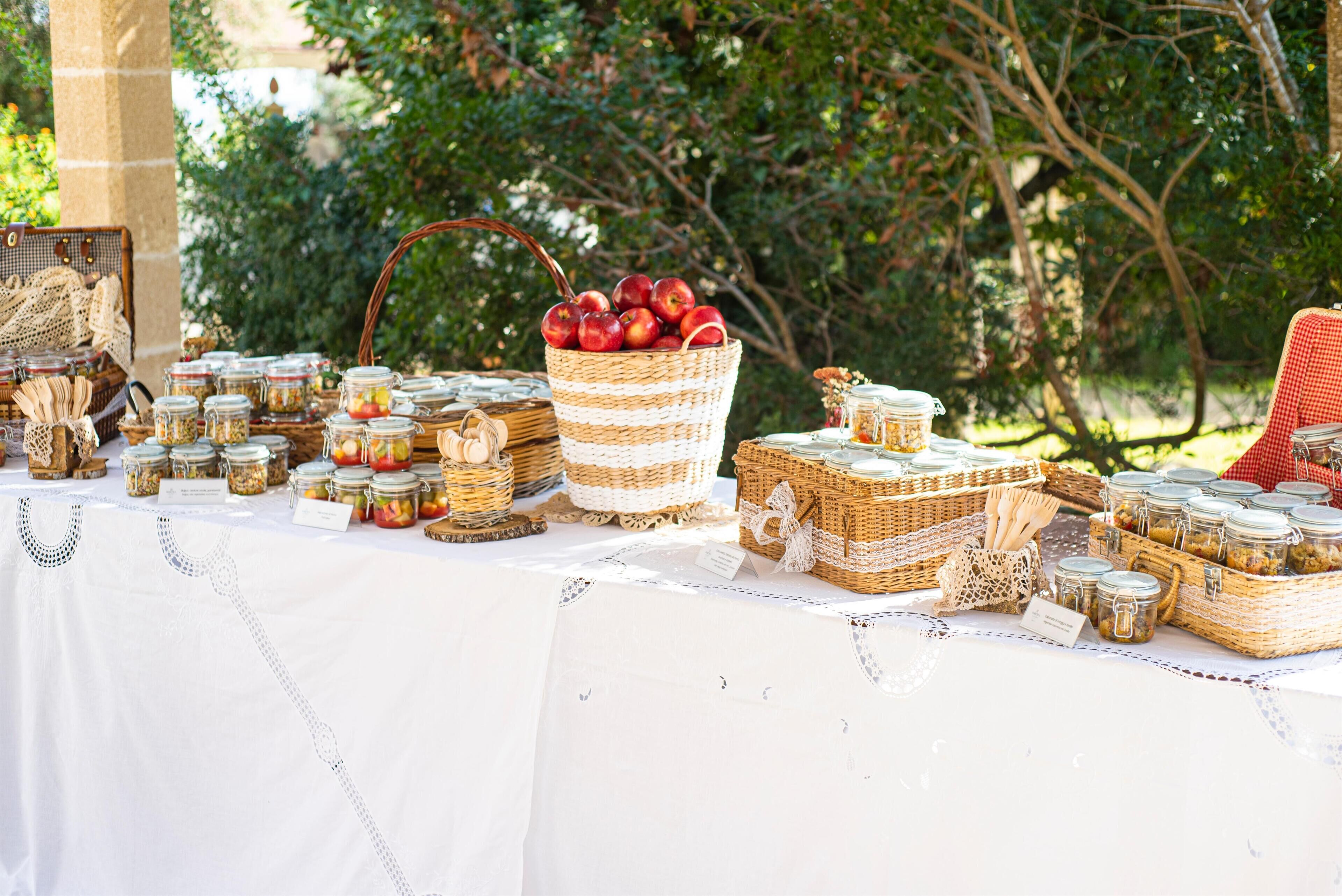 A table set outdoors with various food items and baskets.