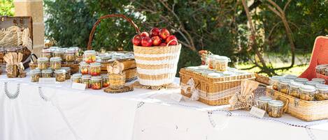 A table set outdoors with various food items and baskets.