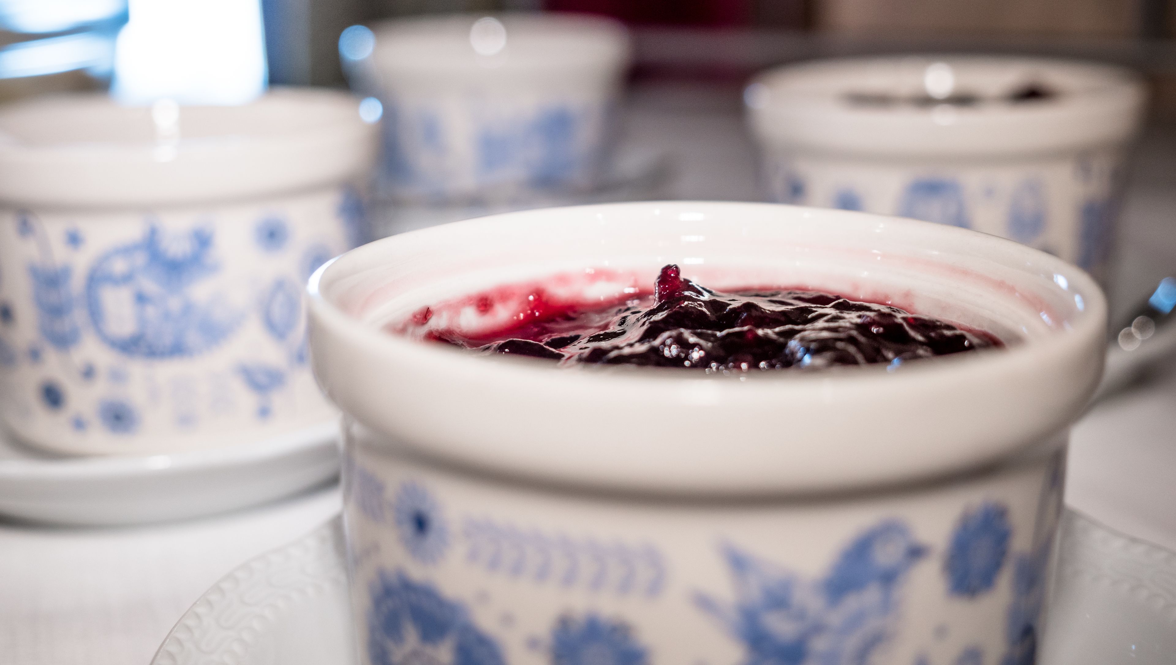 A close-up of a dessert in a ceramic cup with a floral pattern.